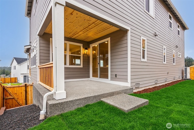 property entrance with a gate, fence, a patio area, and a lawn