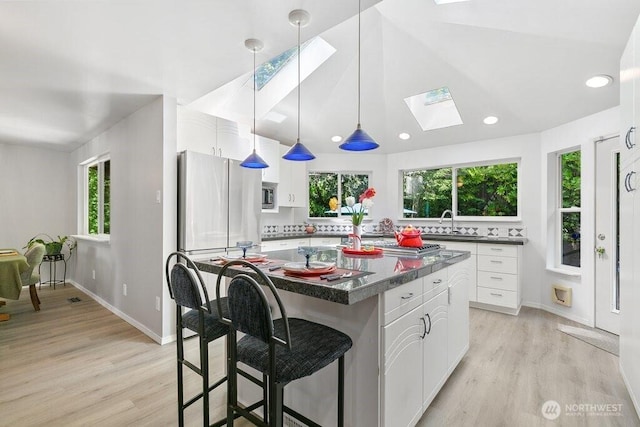 kitchen with white cabinetry, dark countertops, and light wood-type flooring