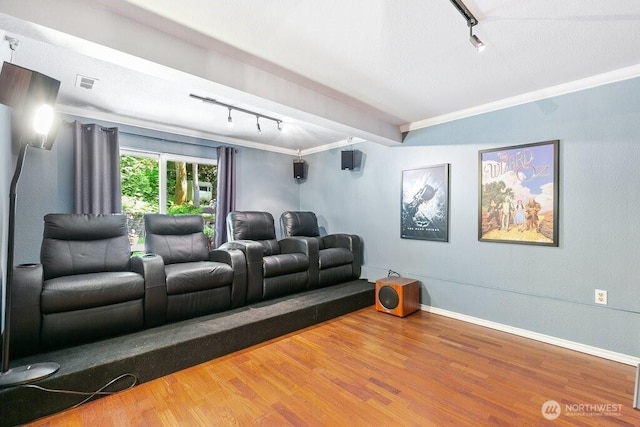 home theater room featuring baseboards, visible vents, track lighting, and wood finished floors
