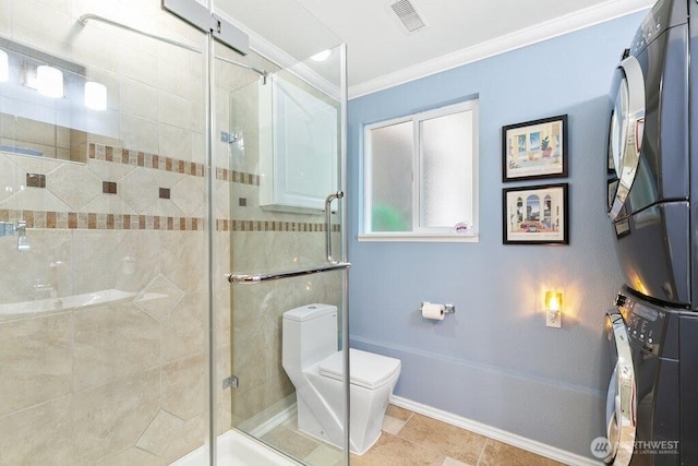 bathroom featuring crown molding, toilet, visible vents, stacked washer and clothes dryer, and a stall shower