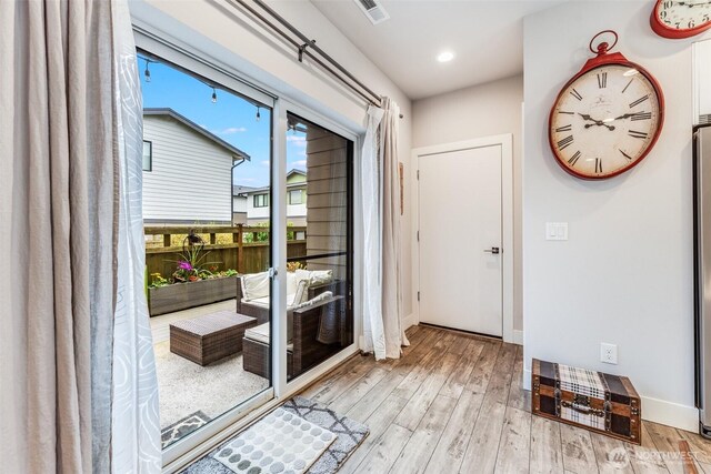 doorway to outside featuring recessed lighting, wood finished floors, visible vents, and baseboards