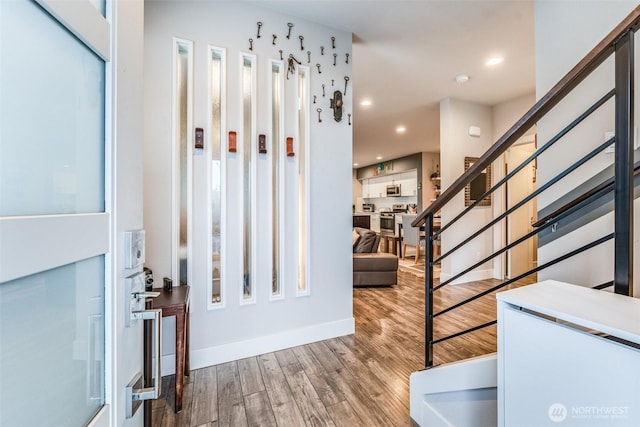entrance foyer with baseboards, stairs, wood finished floors, and recessed lighting