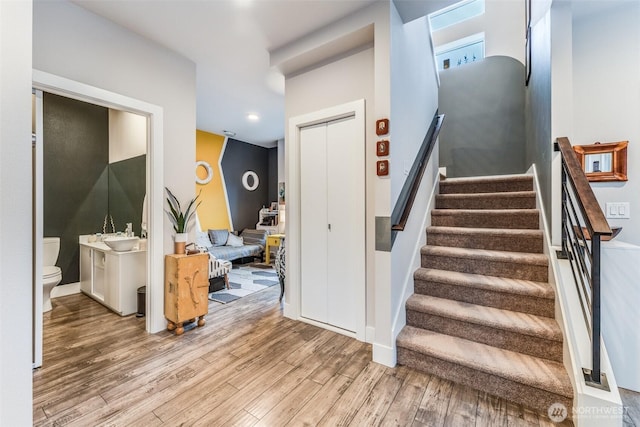 stairs featuring recessed lighting and wood finished floors