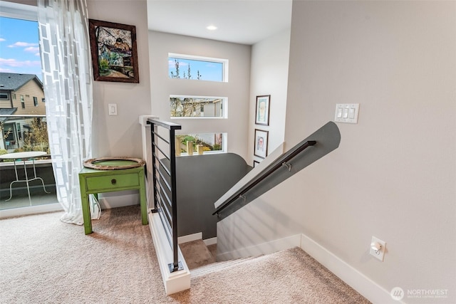 stairs featuring baseboards and carpet flooring