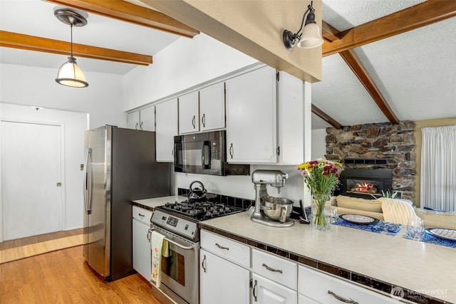 131 E Vine Maple Ln, Union, WA 98592 - kitchen with stainless steel appliances, beam ceiling, white cabinetry, light wood-type flooring, and decorative light fixtures