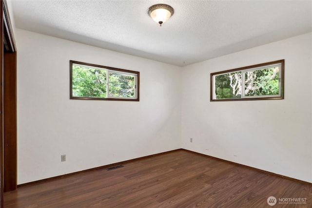 1315 Mill Ave, Bellingham, WA 98225 - empty room featuring dark wood finished floors, baseboards, and a textured ceiling