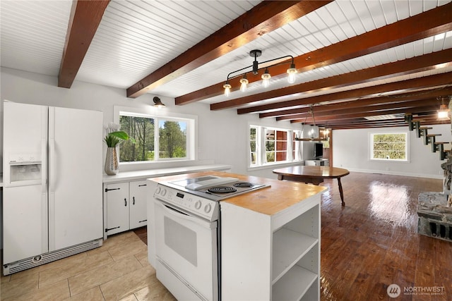 kitchen with a healthy amount of sunlight, beamed ceiling, and white appliances