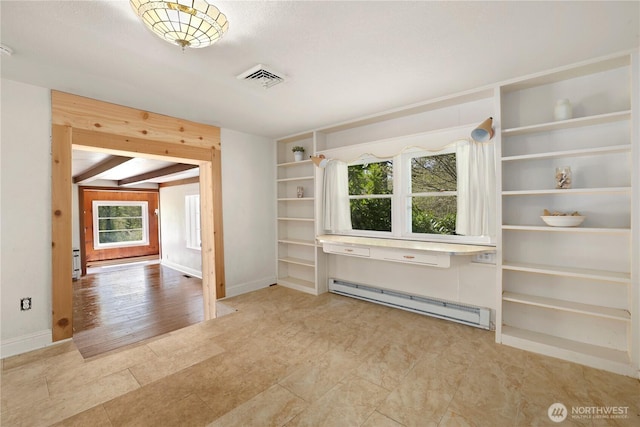interior space with visible vents, built in features, a baseboard heating unit, and baseboards