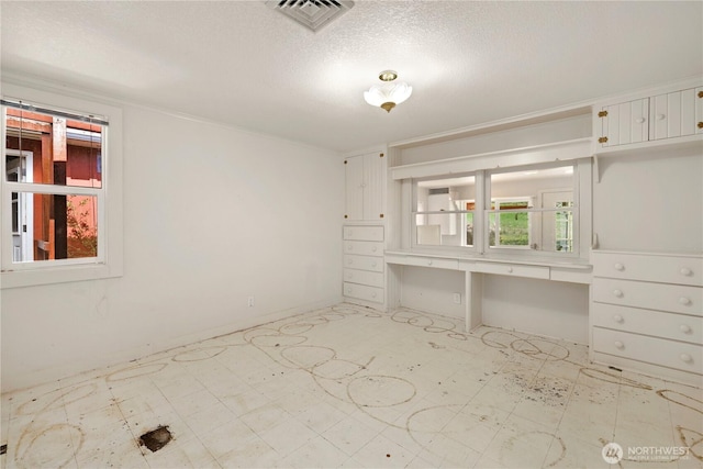 spare room featuring tile patterned floors, visible vents, and plenty of natural light
