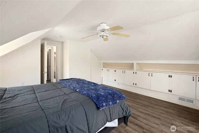 bedroom featuring lofted ceiling, ceiling fan, visible vents, a textured ceiling, and dark wood-type flooring