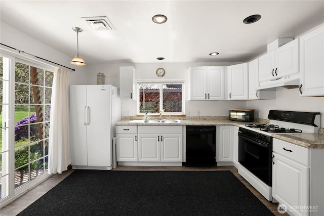 kitchen featuring a sink, freestanding refrigerator, gas range, under cabinet range hood, and black dishwasher