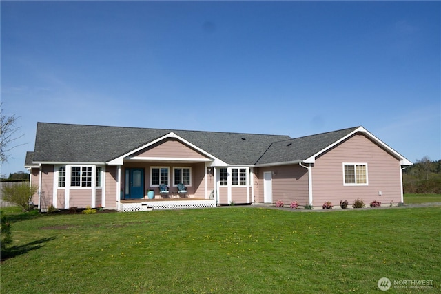 ranch-style house featuring a porch, a shingled roof, and a front yard