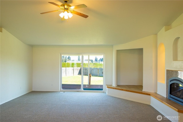 61 Stacey Ct, Sequim, WA 98382 - unfurnished living room featuring carpet floors, a tiled fireplace, ceiling fan, and baseboards