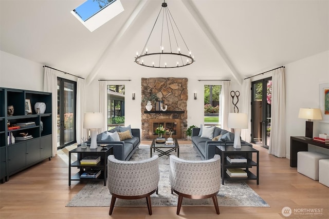 living area featuring a chandelier, a skylight, light wood-style floors, high vaulted ceiling, and beamed ceiling
