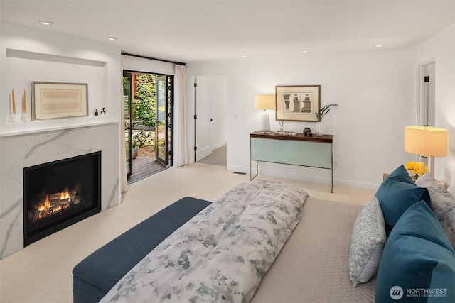 carpeted living area with baseboards, a fireplace, and recessed lighting