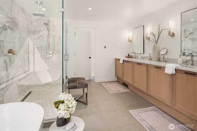 bathroom featuring a marble finish shower, double vanity, recessed lighting, and baseboards