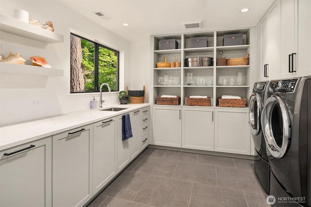 washroom featuring cabinet space, washer and clothes dryer, dark tile patterned floors, and recessed lighting