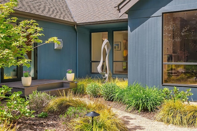 property entrance featuring a shingled roof