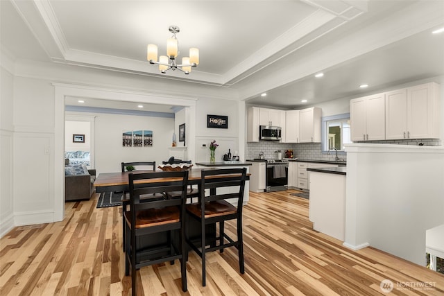 119 37th Ave E, Seattle, WA 98112 - dining area featuring ornamental molding, a chandelier, light wood finished floors, and recessed lighting