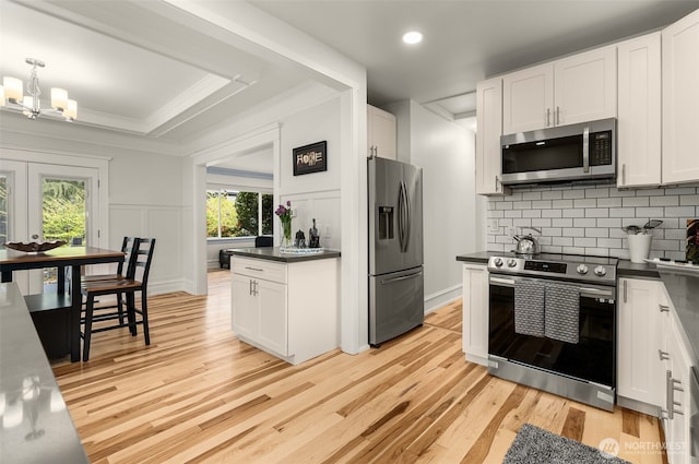 119 37th Ave E, Seattle, WA 98112 - kitchen with a decorative wall, dark countertops, decorative backsplash, light wood-type flooring, and stainless steel appliances