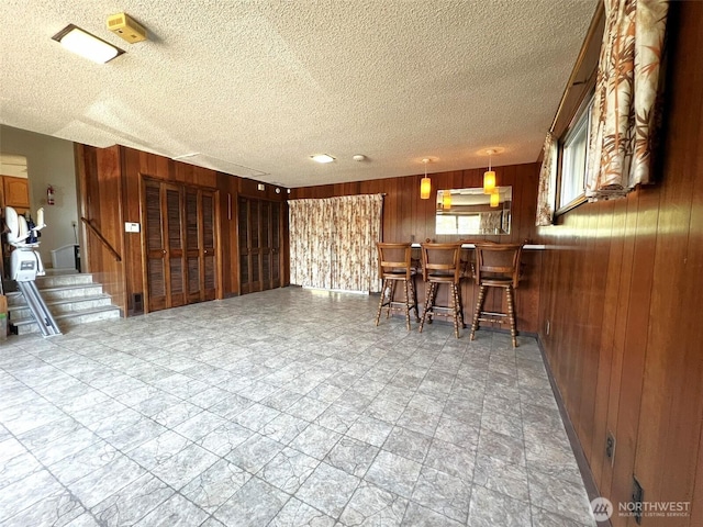 2116 Cascade Way, Longview, WA 98632 - interior space with wooden walls, a dry bar, a textured ceiling, and stairway