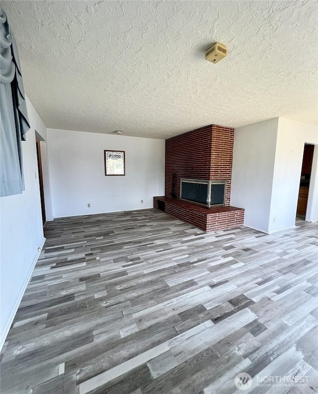 2116 Cascade Way, Longview, WA 98632 - unfurnished living room with wood finished floors, a textured ceiling, and a fireplace