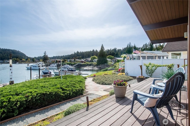 wooden deck with a water view and a dock