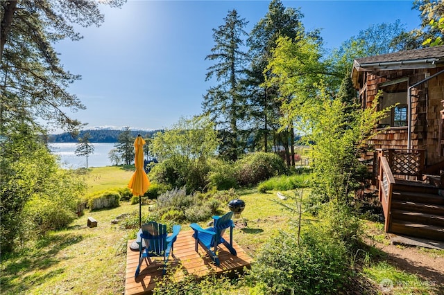 view of yard with a deck with water view