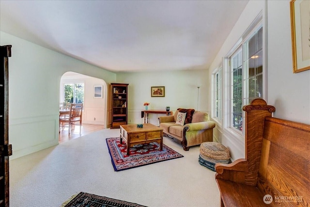 carpeted living room with arched walkways