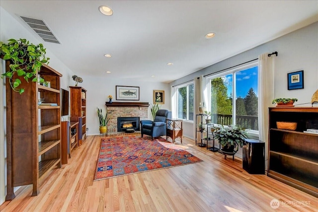 sitting room with recessed lighting, wood finished floors, visible vents, and a fireplace