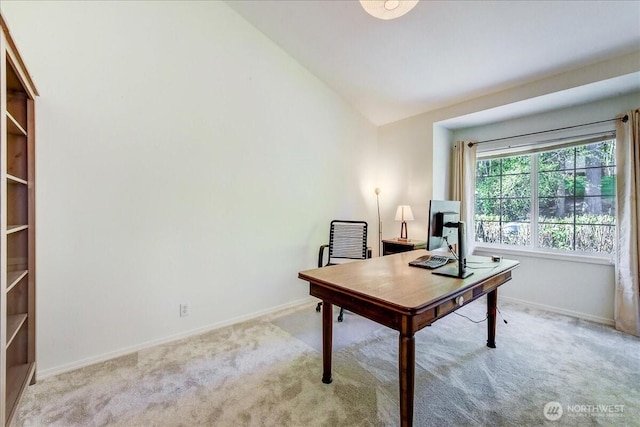 home office featuring light colored carpet, baseboards, and lofted ceiling