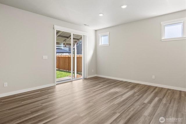 empty room featuring baseboards, recessed lighting, wood finished floors, and visible vents