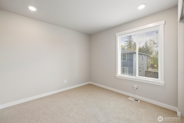 spare room featuring light colored carpet, baseboards, visible vents, and recessed lighting