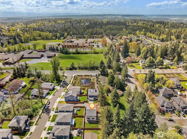 drone / aerial view featuring a residential view and a view of trees