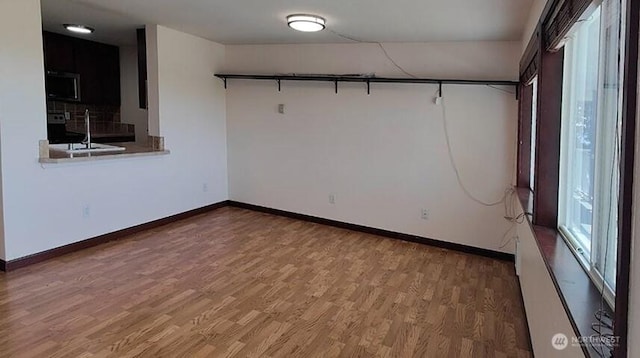 1953 S I St Unit 9, Tacoma, WA 98405 - unfurnished room featuring a sink, baseboards, and wood finished floors