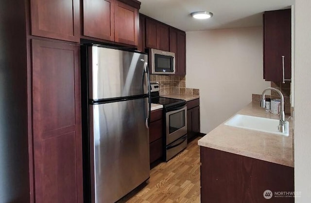 1953 S I St Unit 9, Tacoma, WA 98405 - kitchen featuring light wood-style floors, light countertops, tasteful backsplash, a sink, and stainless steel appliances