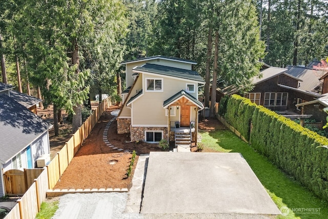 view of front of house featuring a fenced backyard and stone siding