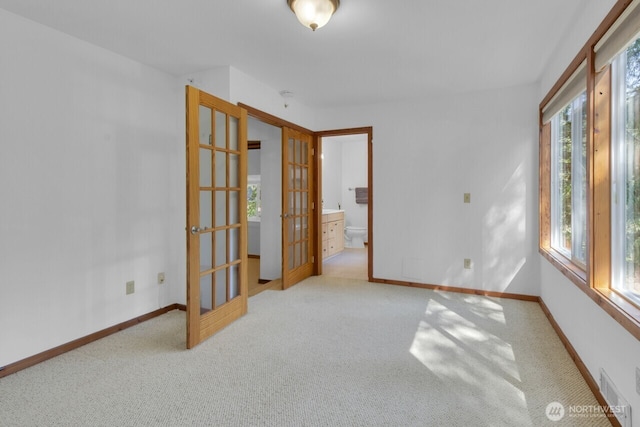 spare room with carpet, visible vents, french doors, and baseboards