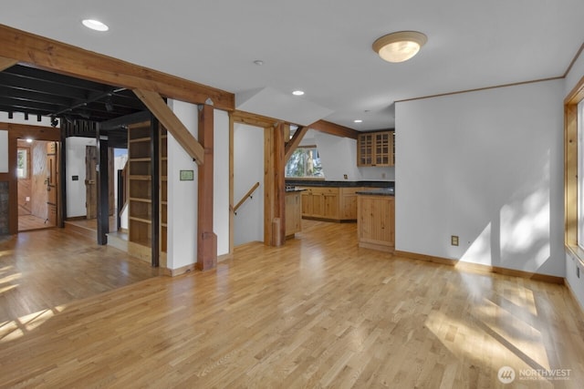 unfurnished living room with recessed lighting, light wood-style flooring, and stairway