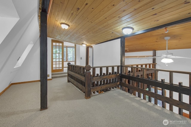interior space featuring lofted ceiling, carpet, a ceiling fan, baseboards, and wood ceiling