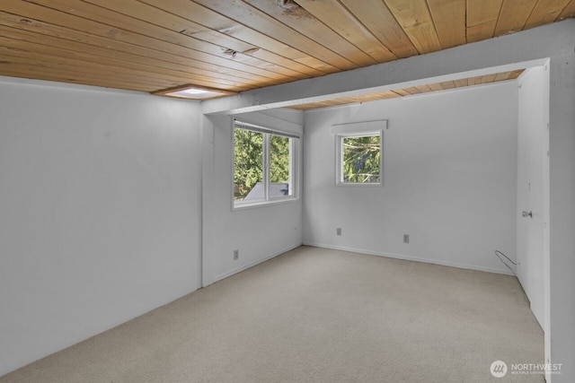 spare room featuring carpet flooring and wood ceiling