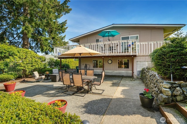 rear view of house with outdoor dining area and a patio area