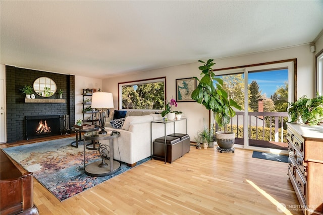 living room featuring a brick fireplace and wood finished floors
