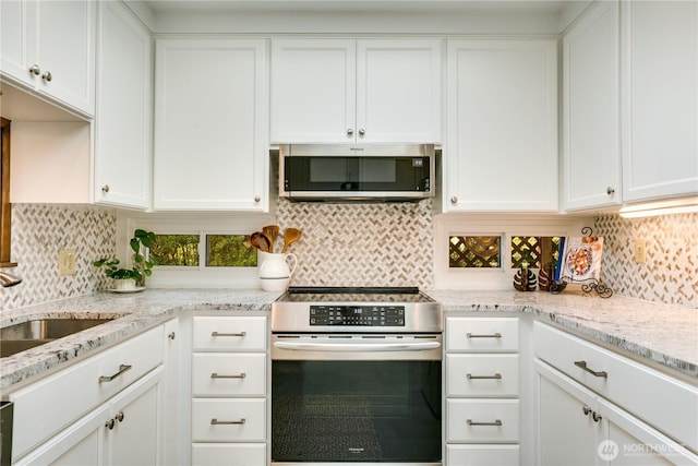 kitchen featuring a sink, tasteful backsplash, white cabinets, and stainless steel appliances