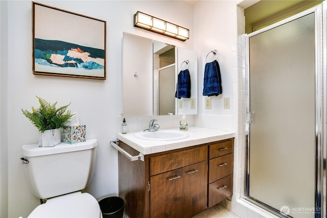 bathroom featuring vanity, toilet, and a stall shower