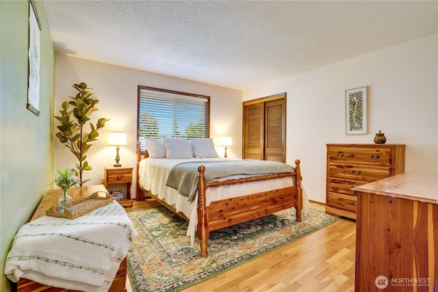 bedroom with light wood-style floors, a closet, and a textured ceiling