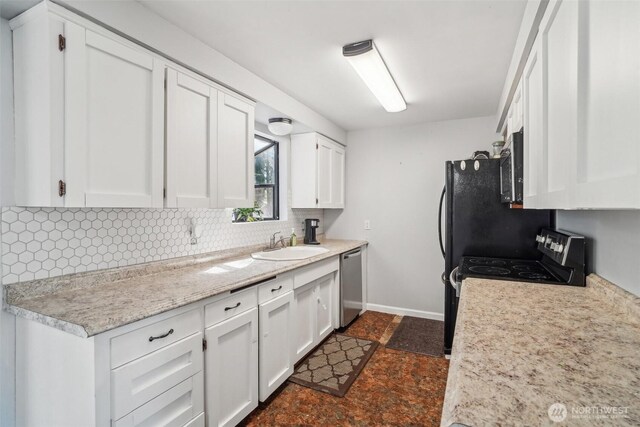 kitchen featuring backsplash, appliances with stainless steel finishes, a sink, light countertops, and white cabinets