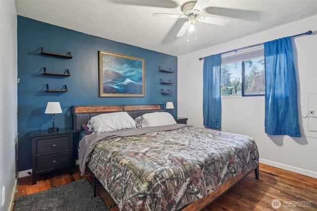 bedroom with a ceiling fan, baseboards, and wood finished floors