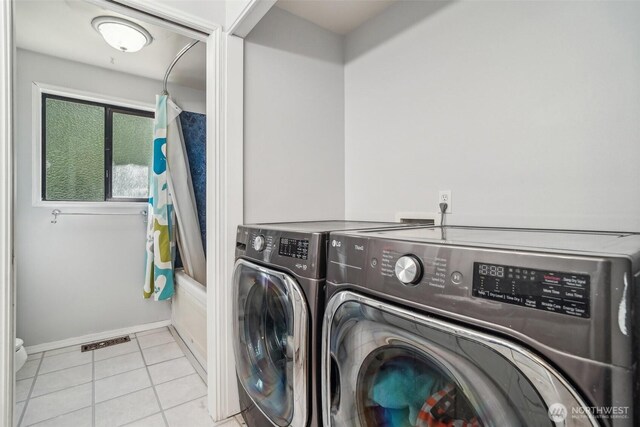 clothes washing area with laundry area, visible vents, tile patterned flooring, baseboards, and washer and dryer