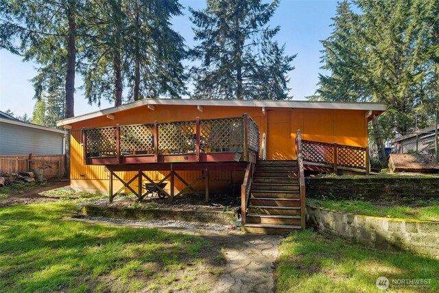 back of property with fence, stairway, and a deck